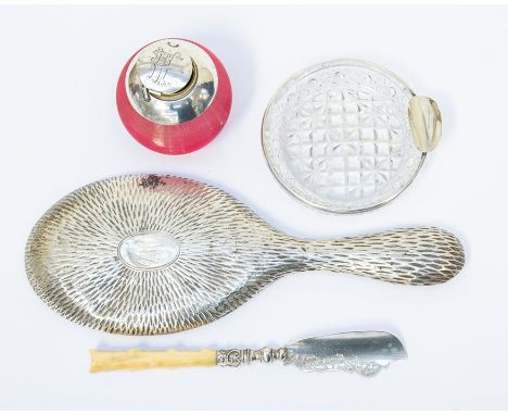 A cranberry glass inkwell with silver cap and cover, hinge is AF, an ivorine handled butter knife, cut glass ashtray with sil
