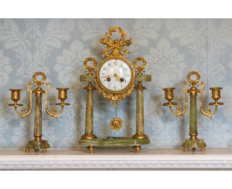 A French clock garniture, 20th Century, of Baroque design in green onyx with cast gilt metal fittings, 9cm enamel dial with A