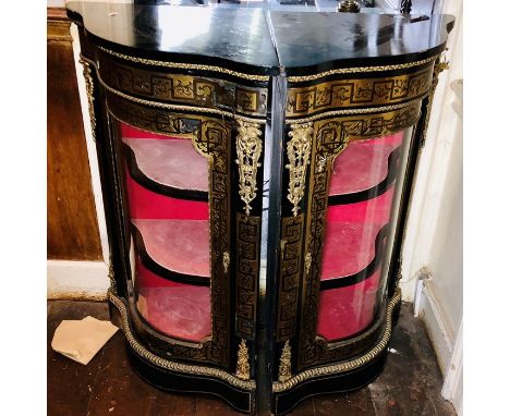 A pair of Victorian ebonised corner credenzas, serpentine shape slight oversailing top, gilt metal mounts with foliage decora