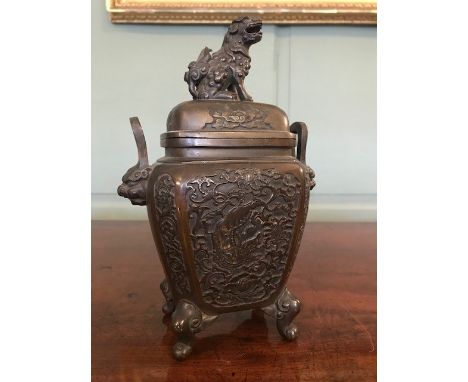 A 19th Century Chinese bronze censer, the domed cover with a Foo dog finial, the vessel with beast mask twin handles, cartouc