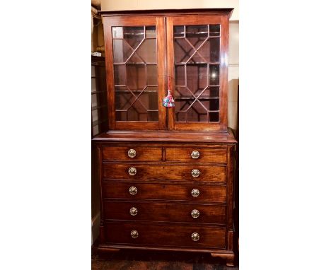 A George IV mahogany secretaire bookcase, circa 1825, moulded cornice above twin astragal glazed panel bookcase, enclosing tw