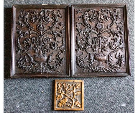 A pair of early carved oak panels, probably 17th Century, each carved in relief with a vase of scrolling foliage, 51 by 39cm,