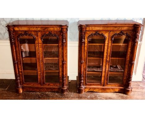 A pair of Victorian figured walnut pier cabinets, circa 1850, rectangular moulded edge top, above twin glazed panel doors mou