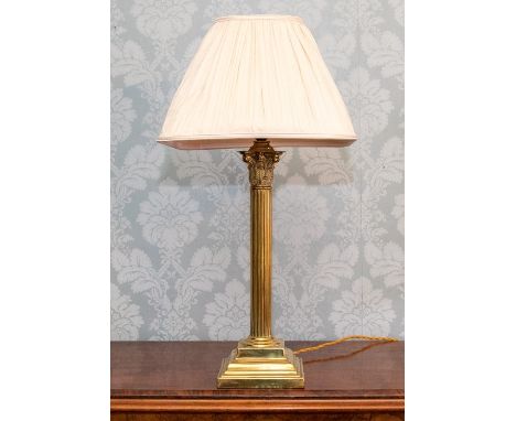 A Victorian brass corinthian column table lamp on stepped plinth, with a pleated fabric shade, (converted from an oil lamp in