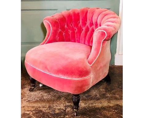 A late Victorian parlour tub chair, circa 1890, scroll top button back pink velvet upholstery, raised on ring turned legs, on