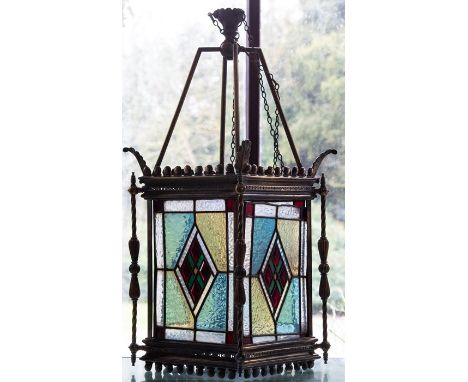 A late Victorian brass hall pendant lantern, circa 1880, of square section with four leaded stained glass panels, suspension 
