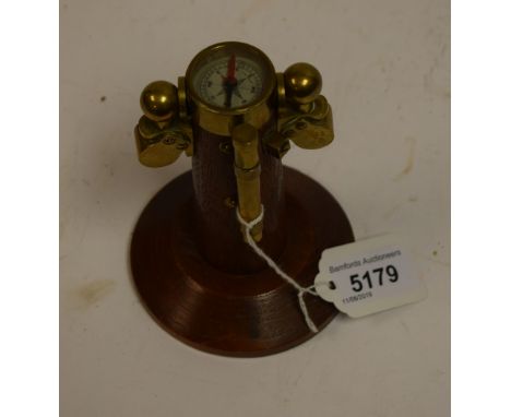An oak and brass novelty desk model, of a ship's compass, circular base, 13cm high