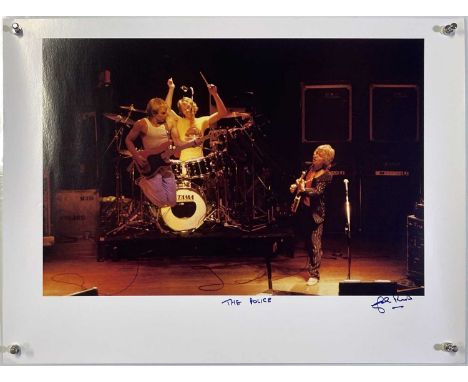 A high-quality photo print of a photograph by John Rowlands depicting Sting and the Police onstage. Signed and titled by the 
