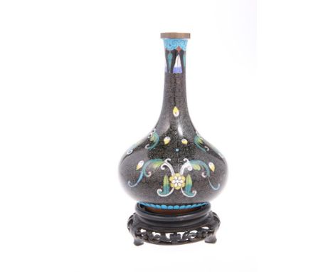 A CHINESE CLOISONNE ENAMEL BOTTLE VASE, raised on a hardwood stand. Overall 21cm high