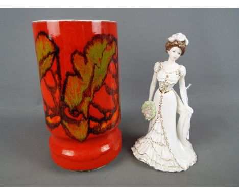 A Poole Pottery Delphis vase, numbered 84, monogram to the base, approximately 23 cm (h) and a Coalport Golden Age figurine '