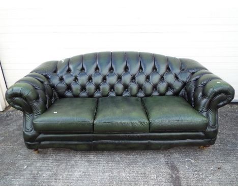 A green leather, three seat, Chesterfield sofa.