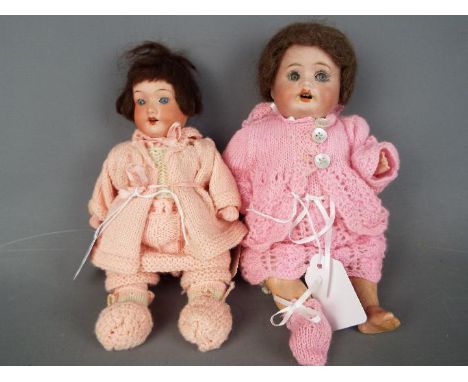 Armand Marseille - a pair of ceramic faced dolls consisting of a n Armand Marseille girl doll with ceramic head, painted eyeb