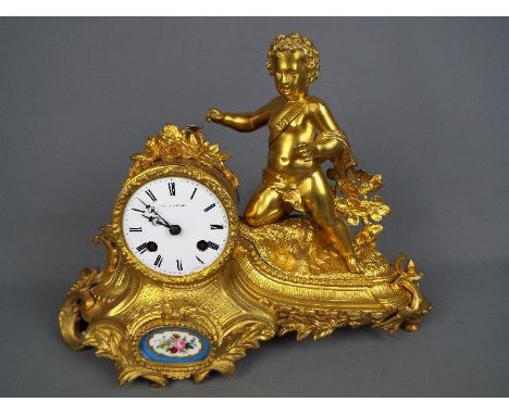 A good, floral and rococo-styled ormolu French mantel clock, the case having the figure of a young boy, inset porcelain panel
