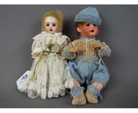 Heubach Koppelsdorf - a set of two ceramic faced dolls to include a boy baby doll with ceramic head, moving brown eyes, paint