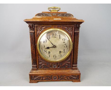 A highly carved wooden mantle clock with pendulum, approx 38 cm x 27 cm