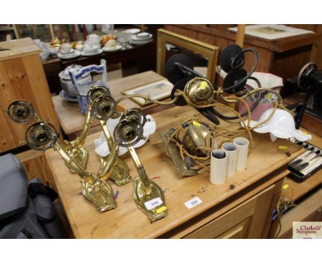 Two black iron wall lights by Jim Lawrence; a brass up and down light fitting and shades; and two double brass wall lights an