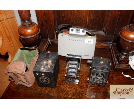 A vintage Polaroid camera, a box Brownie, a Voightlander and another 