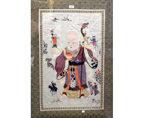 An Oriental Chinese-style embroidered picture showing a wise man holding a stick with dragon head, various figures around pla