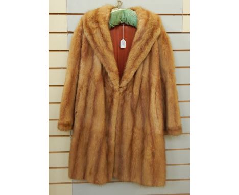 A vintage mink coat with bell sleeves, full-length and a deep shawl collar 