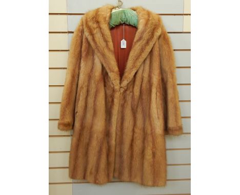 A vintage mink coat with bell sleeves, full-length and a deep shawl collar 