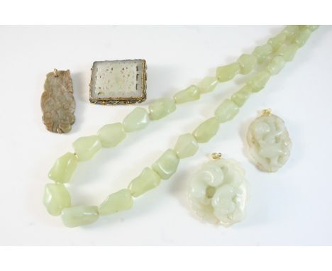 A CARVED AND PIERCED JADE BROOCH mounted in a gilt frame with enamel decoration, together with two carved jade pendants etc.