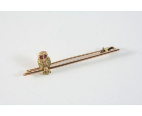 A 9CT. GOLD OWL BROOCH with cabochon ruby eyes, 5cm. long. With box.