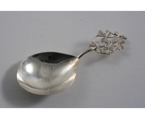 AN EDWARDIAN CADDY SPOON with a drop-shaped bowl, the openwork stem decorated with shamrock / clover leaves, by Michael Fack,