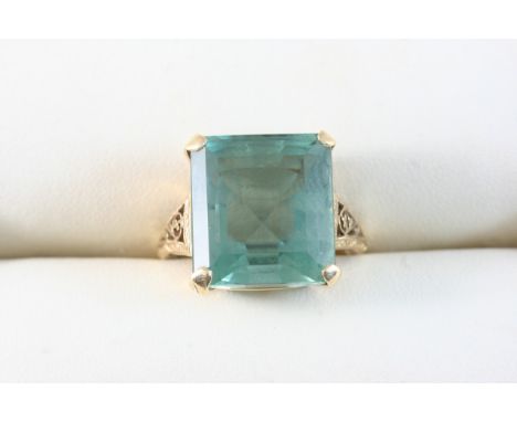 A BLUE TOPAZ SINGLE STONE RING set with a rectangular-shaped topaz, in gold. Size K 1/2.