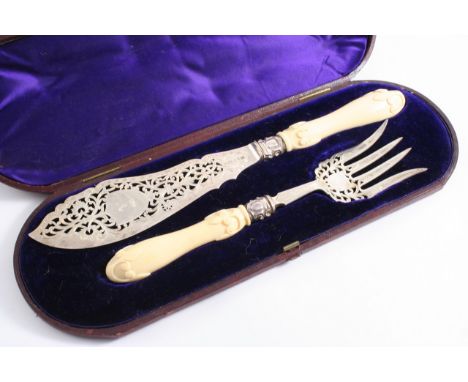 A VICTORIAN CASED PAIR OF FISH SERVERS with carved ivory handles & pierced and engraved blade & tines, crested, by R. Martin 