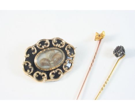 A GOLD FOX MASK STICK PIN together with another stick pin set with a garnet, and a Victorian gold and black enamel brooch, th