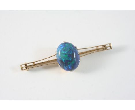 A BLACK OPAL AND GOLD BROOCH set with an oval cabochon black opal in gold, 6.5cm. long.