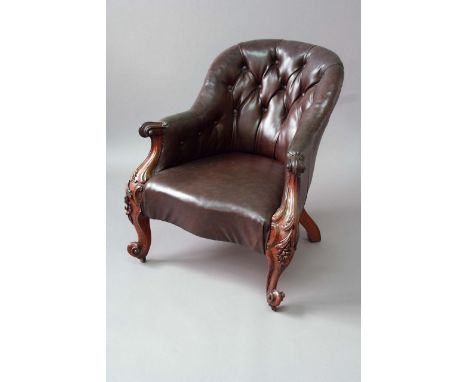 A VICTORIAN ROSEWOOD SALON CHAIR with button leather upholstery and bold sinuous foliate carved arms and legs
