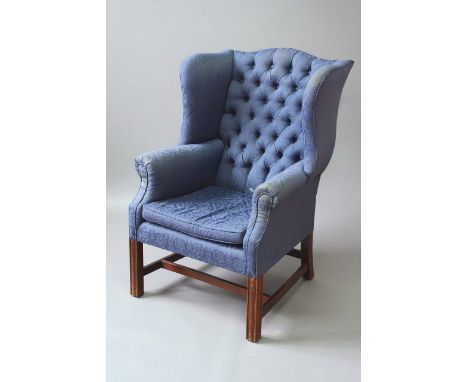 A GEORGE III STYLE MAHOGANY WINGBACK ARMCHAIR button upholstered, on moulded square legs