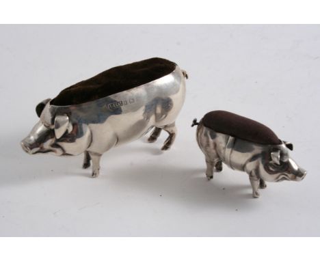 A NOVELTY PIN CUSHION in the form of standing pig and another smaller example (which was originally attached to a cart), both