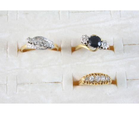 A SAPPHIRE AND DIAMOND THREE STONE RING set with a circular-cut sapphire and two small diamonds, in 18ct. gold, size P, toget