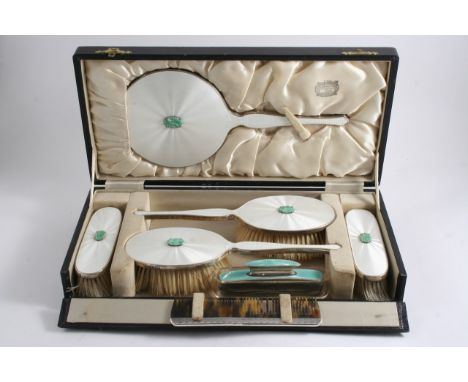 A CASED MODERN DRESSING TABLE SET decorated in pearl white enamel & carved jade bosses comprising two hair brushes, two cloth