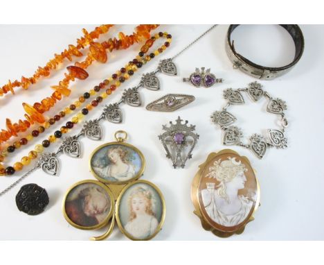 A QUANTITY OF JEWELLERY including a gilt metal triple portrait miniature, an amber necklace, a metal dog collar, a carved she