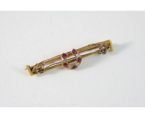 HUNTING INTEREST: a ruby, diamond and gold stock pin, the horseshoe set with circular-cut rubies and diamonds, with two gold 