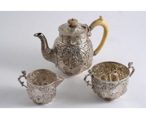 A LATE VICTORIAN THREE-PIECE BACHELOR'S TEA SET with embossed decoration, the tea pot with an ivory handle & finial, by J. Wa