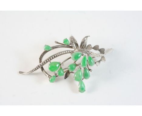 A JADE AND WHITE GOLD FOLIATE SPRAY BROOCH formed with pear-shaped jade cabochons, in 18ct. white gold, 7cm. long.