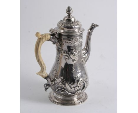 A GEORGE II BALUSTER COFFEE POT partly embossed with flowers, scrolls & husks, ivory handle & bud finial, engraved with two c