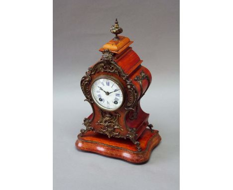 A STAINED BEECH MANTEL CLOCK dial white enamel with blue numerals, movement striking on a gong, case of cartouche shape and a