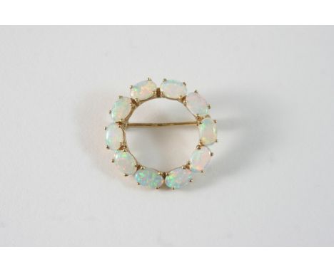 AN OPAL AND GOLD CIRCLE BROOCH set with oval cabochon opals in 9ct. gold, 2.5cm. dia.