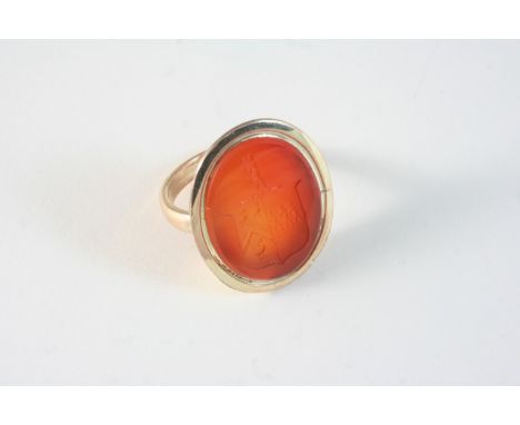 A LARGE GOLD SEAL RING set with an oval-shaped carnelian engraved with coat of arms, 3.5 x 2.75cm. Size R 1/2.