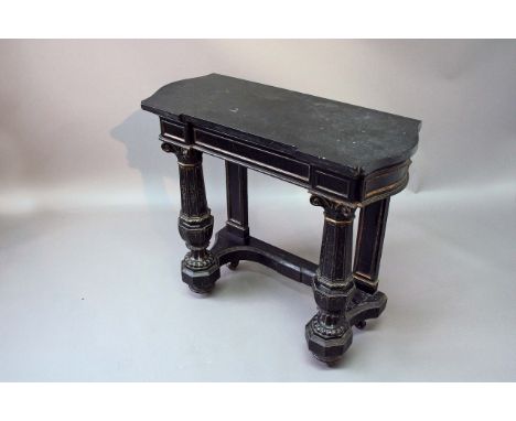 A LATE VICTORIAN EBONISED AND PARCEL GILT CONSOLE TABLE with a breakfront slate top, on octagonal Ionic baluster columns, 33 