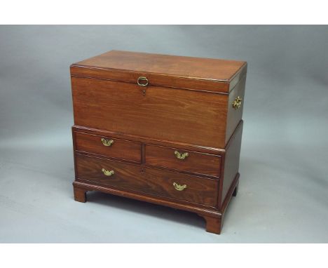 A GEORGE III MAHOGANY TRUNK the lid with caddy moulded edges and bold carrying handles, the stand with two short and one long