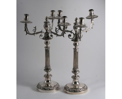 A PAIR OF EARLY 19TH CENTURY ITALIAN FOUR-LIGHT CANDELABRA on round bases with embossed borders & part-fluted columns, the br