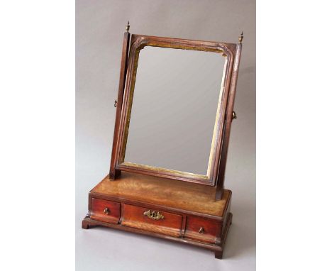 AN EARLY GEORGE III MAHOGANY TOILET MIRROR the rectangular plate with a parcel gilt border, the rectangular plinth with caddy