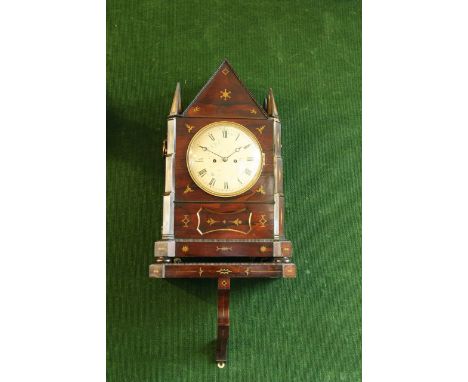 A ROSEWOOD BRACKET CLOCK AND BRACKET dial cream painted, movement striking on a gong, case of Gothic inspiration, inlaid with