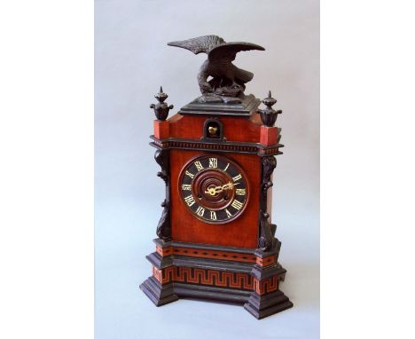 AN EBONISED AND BEECH CUCKOO CLOCK of architectural form, movement with two bellows and a spring gong,  24ins. (61cms.) high 